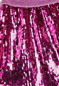 Falda de lentejuelas fucsia con una textura brillante, que presenta una cinturilla elástica ajustada y lentejuelas redondas multicolores brillantes dispuestas verticalmente.