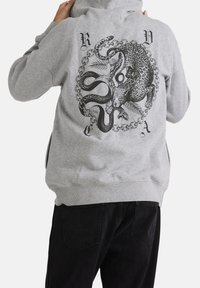 Grijze hoodie met een groot zwart ontwerp op de achterkant, featuring een octopus en een luipaard, omringd door een kettingpatroon. Gemaakt van een katoenmix.