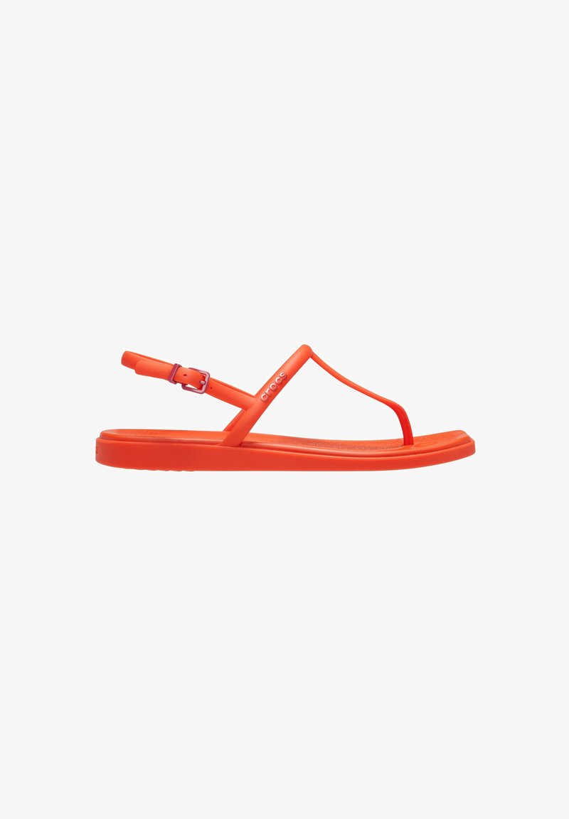 Sandales en plastique orange avec un design à lanières en T, une sangle de cheville ajustable et une semelle intérieure texturée. Construction légère et flexible.
