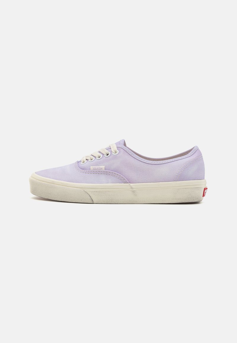 Baskets en toile violet clair avec lacets blancs, semelle en caoutchouc et embout texturé. Présente un logo sur le côté et des coutures blanches contrastantes.