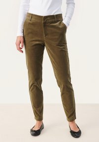 Olijfgroene corduroy broek met een slim fit, voorzien van zijzakken en een gladde textuur, gecombineerd met zwarte ballet flats.