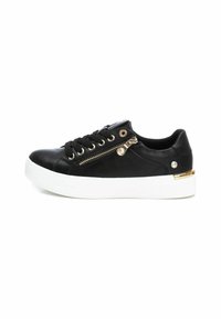 Zapatilla sintética negra con cordones en la parte delantera, cremalleras laterales y suela blanca. Presenta detalles en tono dorado en el costado y en los ojales.