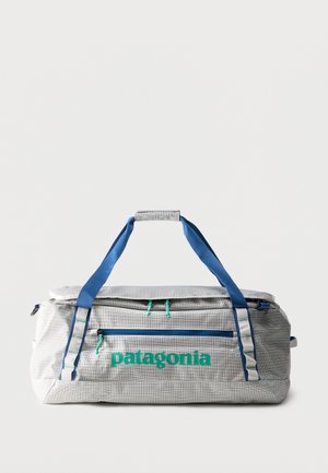 Geantă de voiaj Patagonia gri, cu mânere și fermoare albastre, prevăzută cu un buzunar frontal cu fermoar și mâner căptușit.