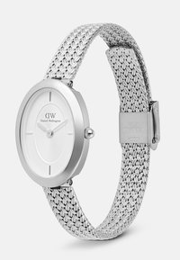 Silver Daniel Wellington watch with a minimalist white face, slim hands, and a woven stainless steel mesh band with clasp.