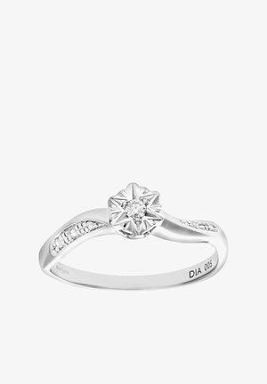 Silver ring with a flower-shaped diamond centerpiece, accented by smaller diamonds along the band on a curved, polished surface.
