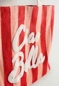 Torebka typu tote w czerwono-różowym paskowanym materiale, z teksturowanym białym napisem "Ciao Bella". Z wzmocnionymi uchwytami.