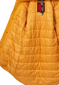 Yellow puffer jacket interior, featuring quilted texture, smooth synthetic material, and a bold red label with black ribbon detail.