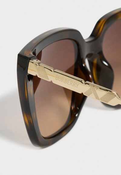 Lunettes de soleil à monture écaille, verres dégradés marron et branches en métal doré avec logo "Burberry" gravé.