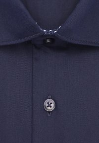 Marineblauwe overhemdkraag met een enkele zwarte knop en een zilveren knop eronder. Zichtbare stiksels en een vleugje wit patroon binnenin de kraag.