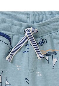 Helle blaue Shorts aus strukturiertem Stoff; ausgestattet mit einem dunkelblauen und weißen gestreiften Kordelzug und maritimen Motiven, darunter Boote und Fische.