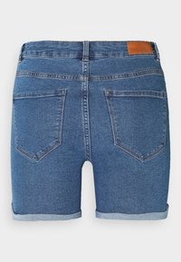 Pantalones cortos de mezclilla azul con dobladillo enrollado, que presentan dos bolsillos traseros y un detalle de cuero marrón en la cintura. Textura suave y diseño clásico.