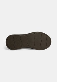 Semelle de chaussure en caoutchouc noir avec une surface texturée et un motif de crampons en zigzag pour l'adhérence. Bords épais avec une finition lisse sur les côtés.