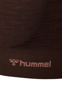 Bruin gebreide stof met een gestructureerd patroon en een zichtbaar logo in een lichtere tint. Soepele afwerking met subtiele ontwerpelementen.