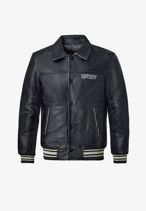 Schwarze Lederjacke mit durchgehender Knopfleiste, gerippten Streifen an den Bündchen und Seitentaschen. Mit CORDON SPORT-Logo in Weiß.