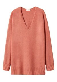 Sweter w serek z miękkiego koralowego materiału, z długimi rękawami i ribbowanym dołem. Faktura wydaje się gładka, a krój jest luźny.