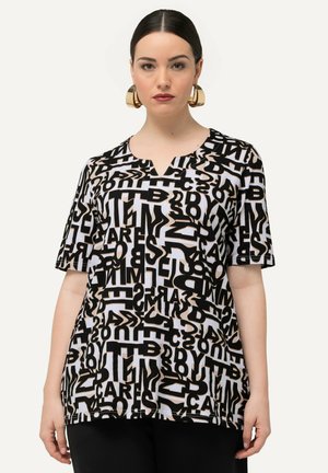 T-shirt grafico bianco e nero con scollo a V, maniche corte e un motivo testuale astratto. Tessuto morbido con una vestibilità rilassata.