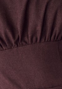 Tela marrón texturizada con detalles fruncidos en la cintura. Acabado suave con un patrón de tejido uniforme.