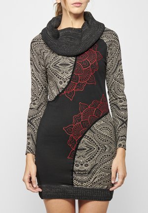 Schwarzes, gemustertes Kleid mit langen Ärmeln, Cowl-Neck und roter Stickerei. Es zeichnet sich durch komplexe geometrische und Paisley-Muster aus und hat eine figurbetonte Form.