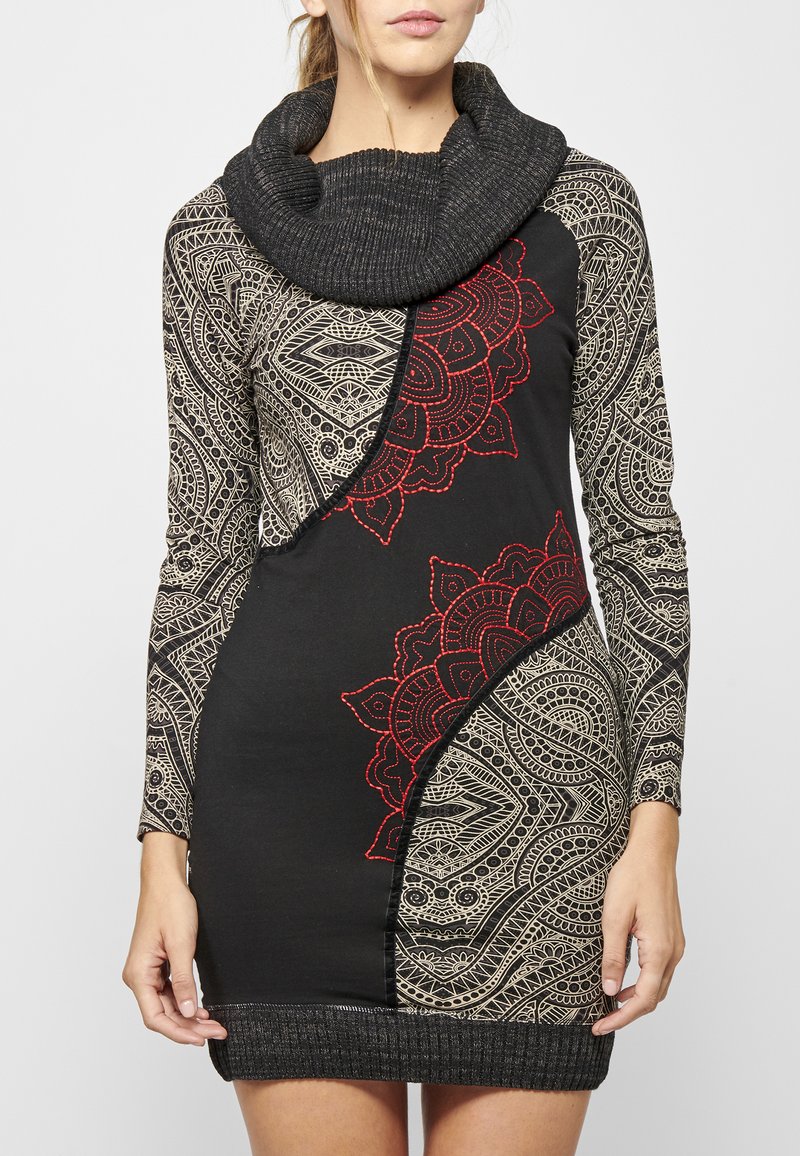Schwarzes, gemustertes Kleid mit langen Ärmeln, Cowl-Neck und roter Stickerei. Es zeichnet sich durch komplexe geometrische und Paisley-Muster aus und hat eine figurbetonte Form.