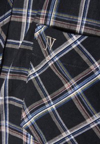 Das Karo-Gewebe weist navyblaue, weiße und bunten Streifen auf. Es enthält eine Tasche mit einem gestickten "JV"-Logo. Weicher Baumwollstoff.