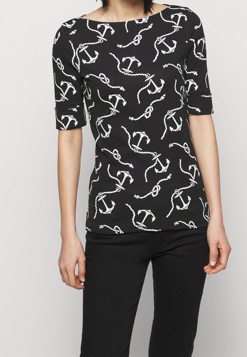 Svart kortärmad topp med ett vitt mönster av ankare och kedjor, med en båtformad halsringning och en smal passform genom hela kroppen.