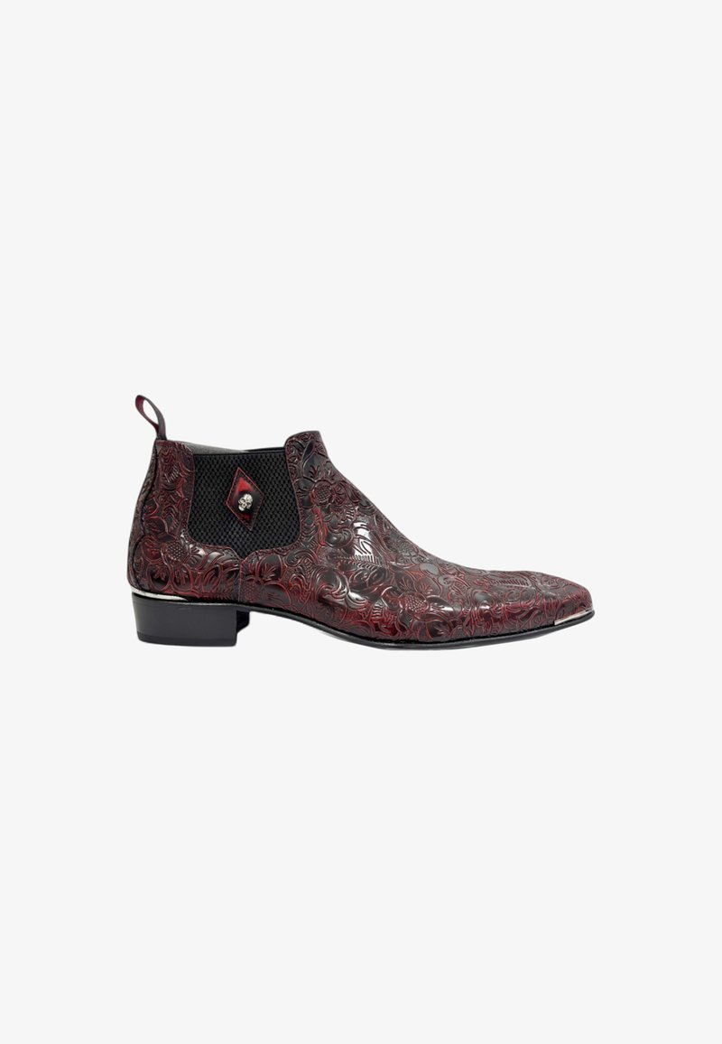 Red leather ankle boots with intricate floral embossing, black elastic side panels, and a rounded toe, featuring a small decorative skull detail.