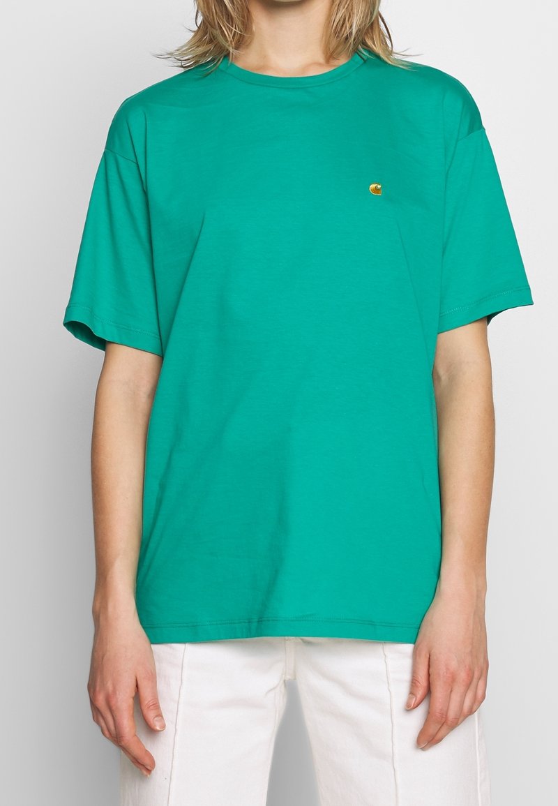 T-shirt en coton vert avec une coupe décontractée, des manches courtes et un petit logo brodé sur la poitrine. Design uni sans motifs ni accents.