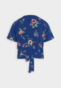 Blå kortærmet crop top med pink og grøn blomsterprint og en knude detalje i kanten bagpå.