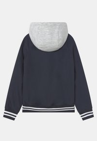 Granatowa kurtka z szarym kapturem, elastycznymi mankietami i paskowymi akcentami. Gładki materiał, casualowy design i luźny krój.