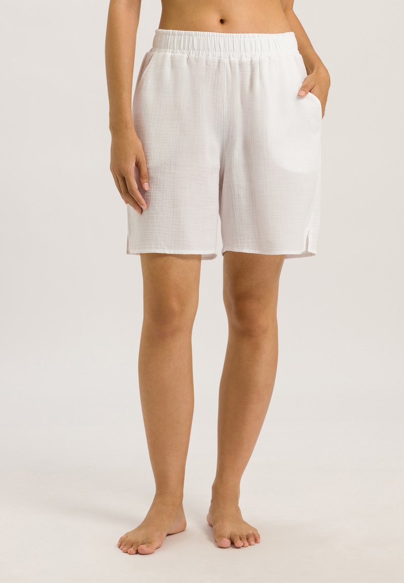 Białe bawełniane szorty z elastycznym paskiem w talii, bocznymi kieszeniami i fakturowanym wykończeniem. Posiadają luźny krój oraz boczne rozcięcia na dolnej krawędzi.