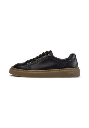 Black low-top leather sneaker with brown rubber sole, black laces, side stitching, and Camper logo embossed near the heel on the sole.
