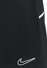 Shorts de sport noirs en tissu texturé, ornés du logo Nike en blanc et d'une rayure d'accentuation contrastante en blanc.