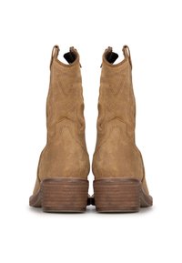 Botas de tobillo de ante marrón con punta afilada, parte superior texturizada y tacón de madera apilado. Presentan costuras visibles y pestañas de tiro a los lados.