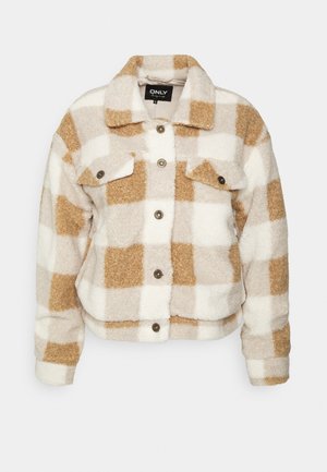Veste polaire à carreaux beige et blanc doux avec boutons sur le devant, deux poches à rabat sur la poitrine et un col, étiquette "ONLY" à l'intérieur du col.