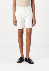 Shorts de mezclilla blanca con corte recto, que cuentan con cierre de botón, cinco bolsillos y un dobladillo limpio. Textura suave y tela ligera.