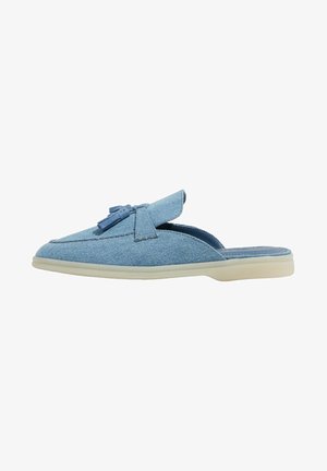 Scarpa slip-on in denim con punta arrotondata, in morbido tessuto blu, dettaglio decorativo con nappine e suola in gomma di colore chiaro.