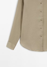 Beige overhemd met lange mouwen, knoopsluiting, een gladde textuur, afgeronde zoom en omslagmanchetten; heeft zes bijpassende knopen aan de voorkant.