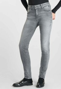 Jeans skinny taille haute gris en denim, avec une texture lisse, un design à cinq poches et une finition légèrement délavée.