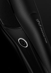 Lisseur à cheveux ghd Chronos Max noir avec une surface texturée et un bouton d'alimentation lumineux.