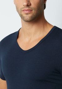 Navy blue v-neck t-shirt made of soft fabric, fitted shape, short sleeves, seamless design with minimal stitching detail.