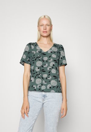Top verde de mangas curtas com um decote em V, apresentando um padrão floral branco contra um fundo escuro. Tecido texturizado com um corte descontraído.