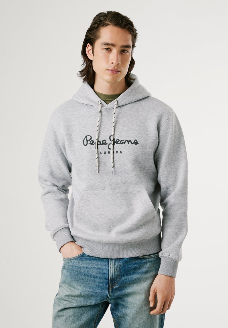 Sudadera gris con un bolsillo canguro, que presenta un texto de logotipo negro en el pecho. Terminada con puños de canalé y capucha ajustable con cordón.