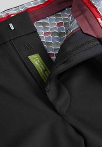 Zwarte broek met ritssluiting, voorzien van een patroon binnenvoering in blauw- en grijstinten, en een groene label met de tekst "sociaal verantwoordelijk."