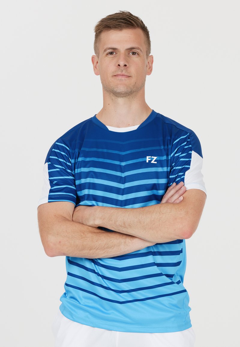 Blå och ljusblå randig sportt-shirt med rund halsringning och korta vita ärmar. Har en "FZ" logotyp på framsidan.