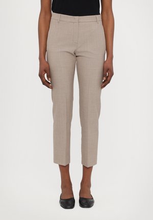 Beige maßgeschneiderte Hosen aus einem strukturierten Stoff, mit geradem Schnitt, verkürzter Länge und flachem Bund. Getragen mit schwarzen, geschlossenen Schuhen.