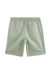 Shorts vert clair en tissu doux, dotés d'une taille élastique et d'une poche arrière unique avec un contour cousu.