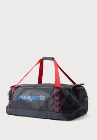 Črna športna torba z rdečimi trakovi, s plavim logotipom "Patagonia", iz trpežnega blaga, z zadrgo in stranskim žepom.