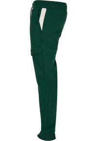 Groene sweatpants met een slim fit, elastische tailleband, zijzakaccenten in het wit en een structuurstof. Bevat een cargozak op de dij.