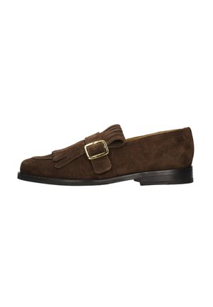 Donkerbruine suède loafer met franjes, gouden gesp en zwarte lage hak tegen een witte achtergrond.