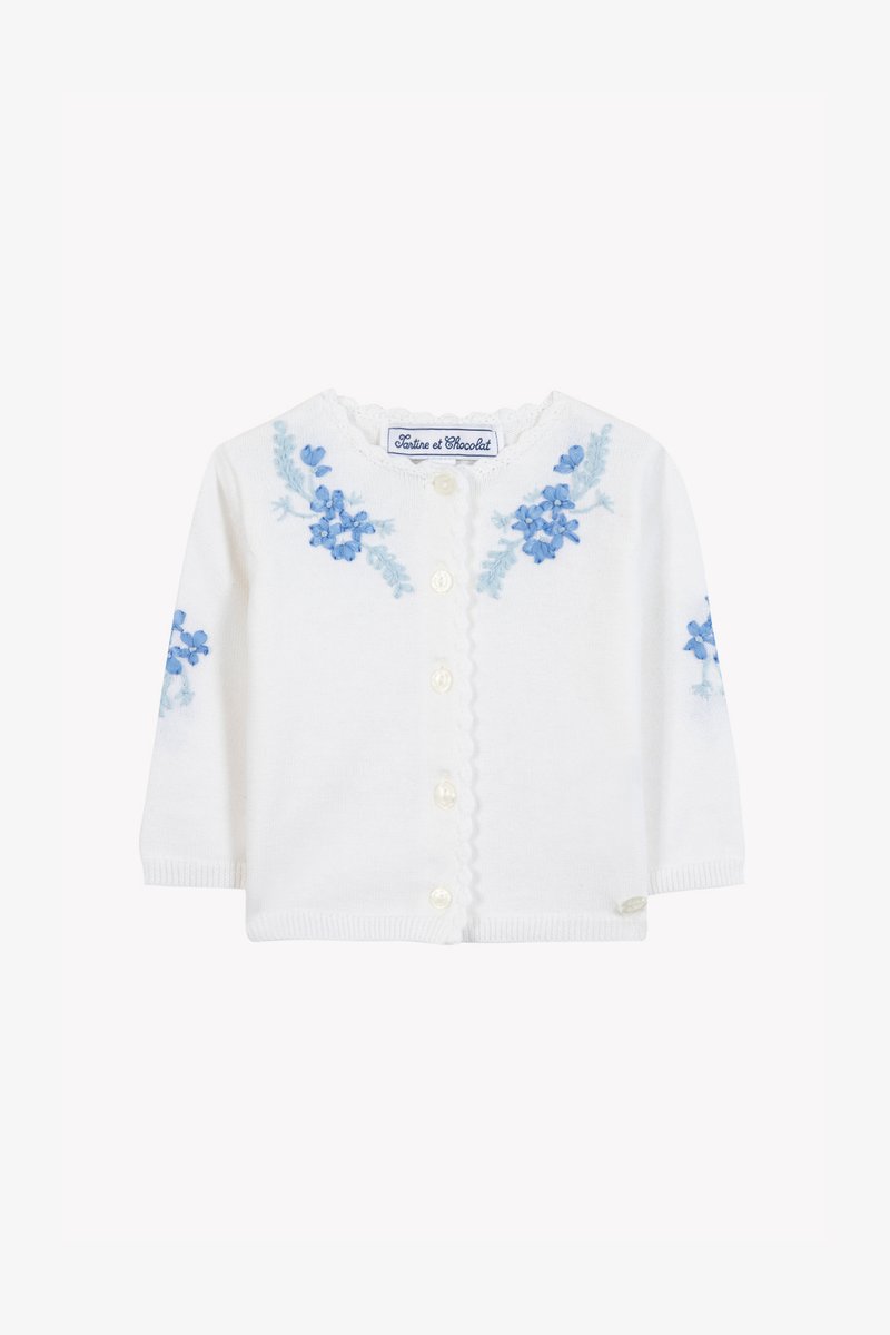 Weißer, gestrickter Cardigan mit langen Ärmeln, auf beiden Seiten mit blauer Blumenstickerei und einem geschwungenen Kragen. Perlmuttknöpfe vorne.